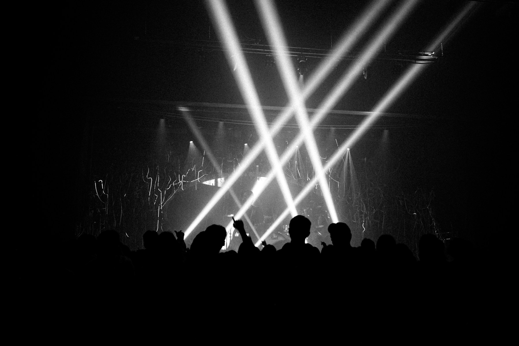 Stage lights illuminating the energy of a live music crowd